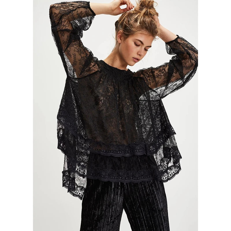 Woman wearing a black lace top and pants on a white background