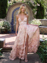 Woman in a floral dress standing outdoors with a decorative arch and plants in the background