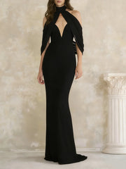 Black evening gown with cut-out design on a neutral background