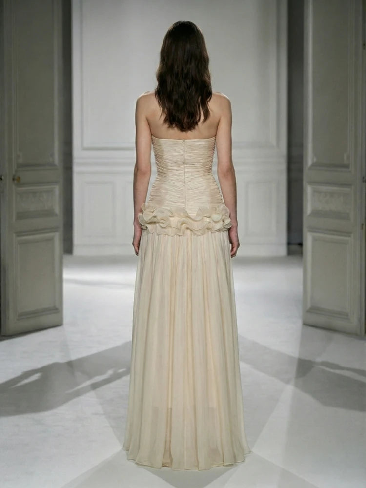 Woman wearing a strapless, ruffled gown in a minimalistic setting