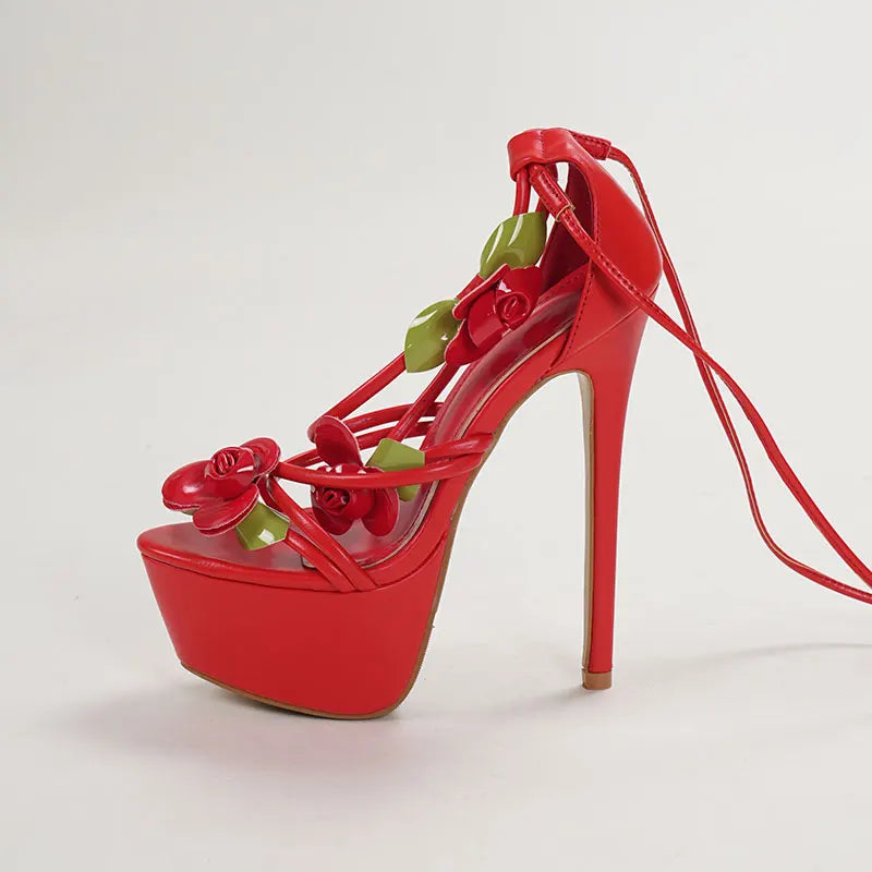 Red high-heeled shoe with floral design on a light gray background