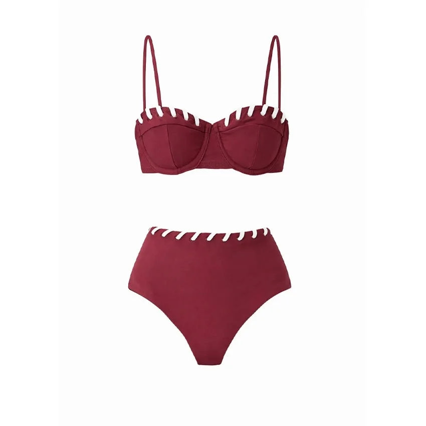 Maroon bikini set with white contrast trim along the edges of the bustier top and high-waisted bottoms.