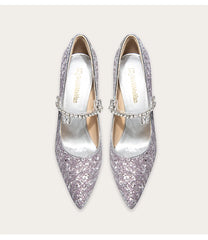 Pair of glittery silver high heels with embellishments on a light background