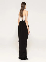 Woman wearing a black evening gown with a white lace bodice on a white background