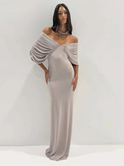 Full length view of a woman in a ruched off-shoulder maxi dress.