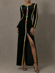 Black dress with gold and red embellishments on a gray background