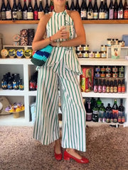 Person wearing a green and white striped outfit in a store setting with shelves of products.