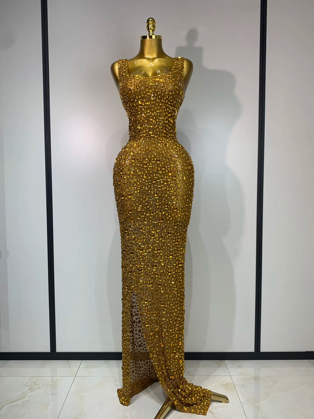 Gold diamond-embellished maxi dress on a mannequin
