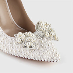 Close-up of the pointed toe of a stiletto heel with a pearl and crystal bow embellishment