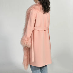Pink coat with feathered sleeves on a plain background