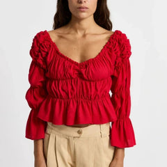Red ruffled blouse worn by a person on a white background