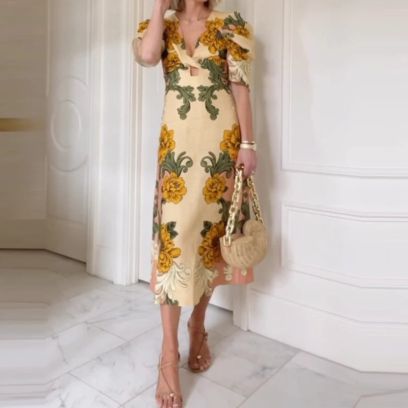 Woman wearing a floral dress holding a handbag in a white room.