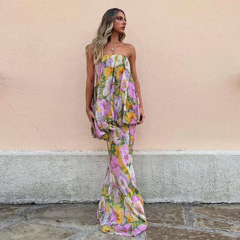 A woman wearing a floral strapless dress against a beige wall.