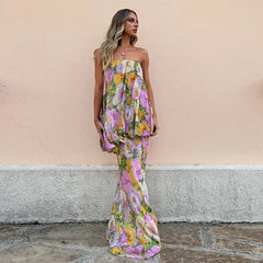 A woman wearing a floral strapless dress against a beige wall.