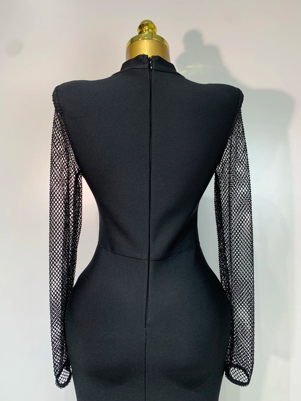 Back view of black knit maxi dress with mesh sleeves