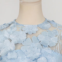 Mannequin wearing a light blue lace dress with floral patterns on a neutral background