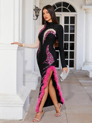 Woman in a black and pink dress with feather details standing in front of a classical building.