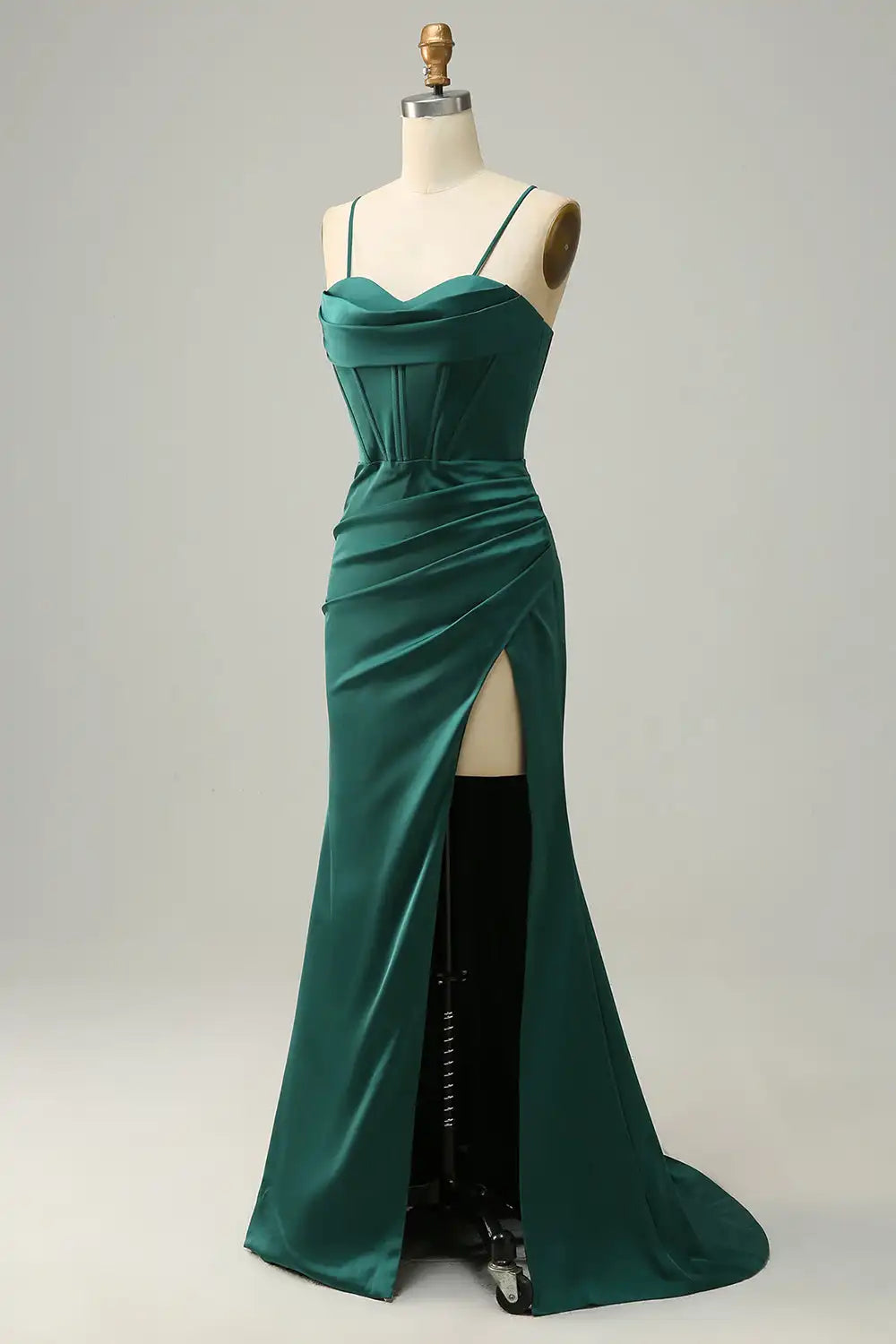 Green evening gown on a mannequin against a plain background