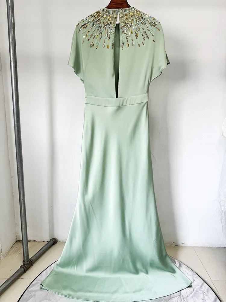 Mint green dress with beaded neckline on a white background
