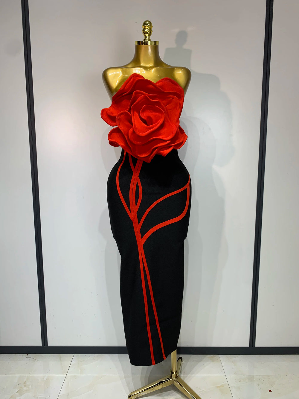 Black strapless sheath dress with red floral applique and red trim