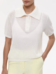 White short-sleeve shirt with a collar worn by a person on a white background
