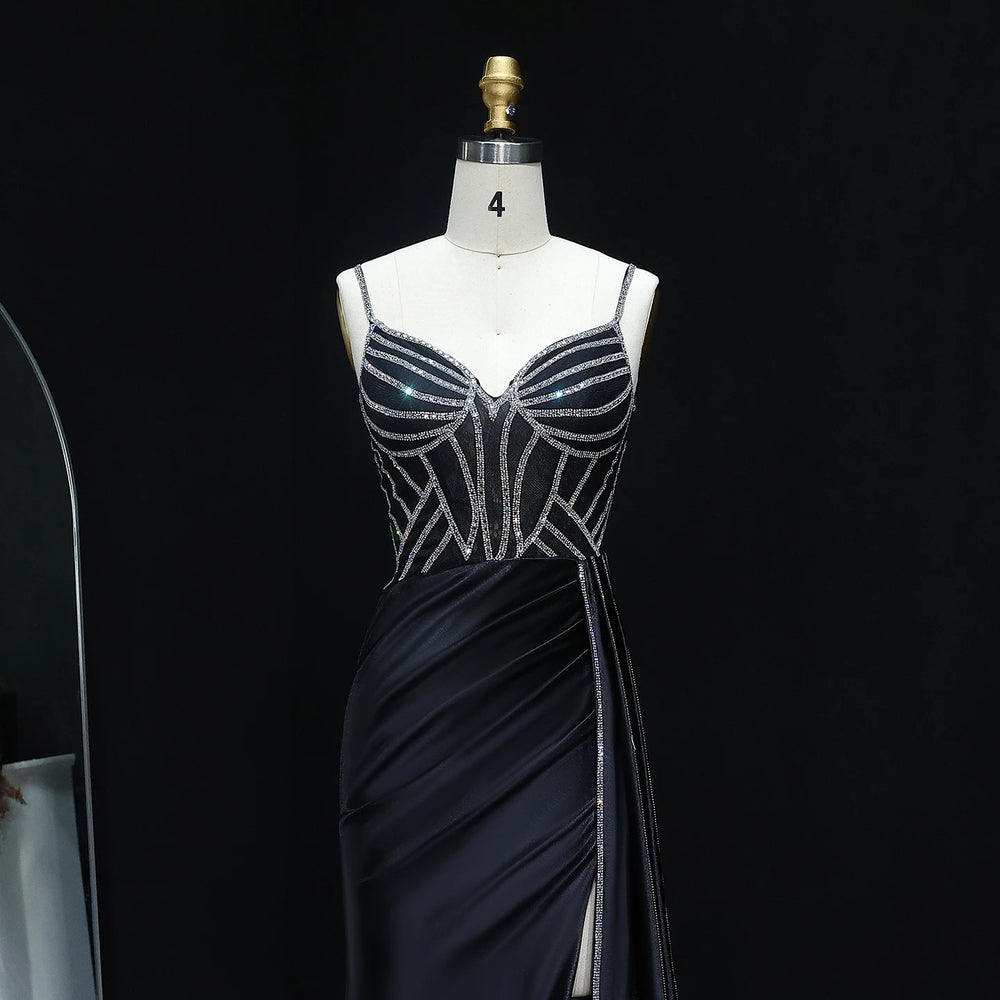 Black evening gown with silver embellishments on a mannequin against a black background