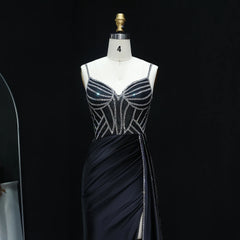 Black evening gown with silver embellishments on a mannequin against a black background