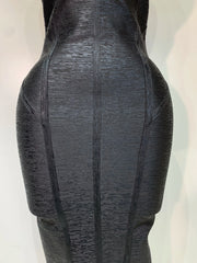 Black textured dress on a mannequin against a white background