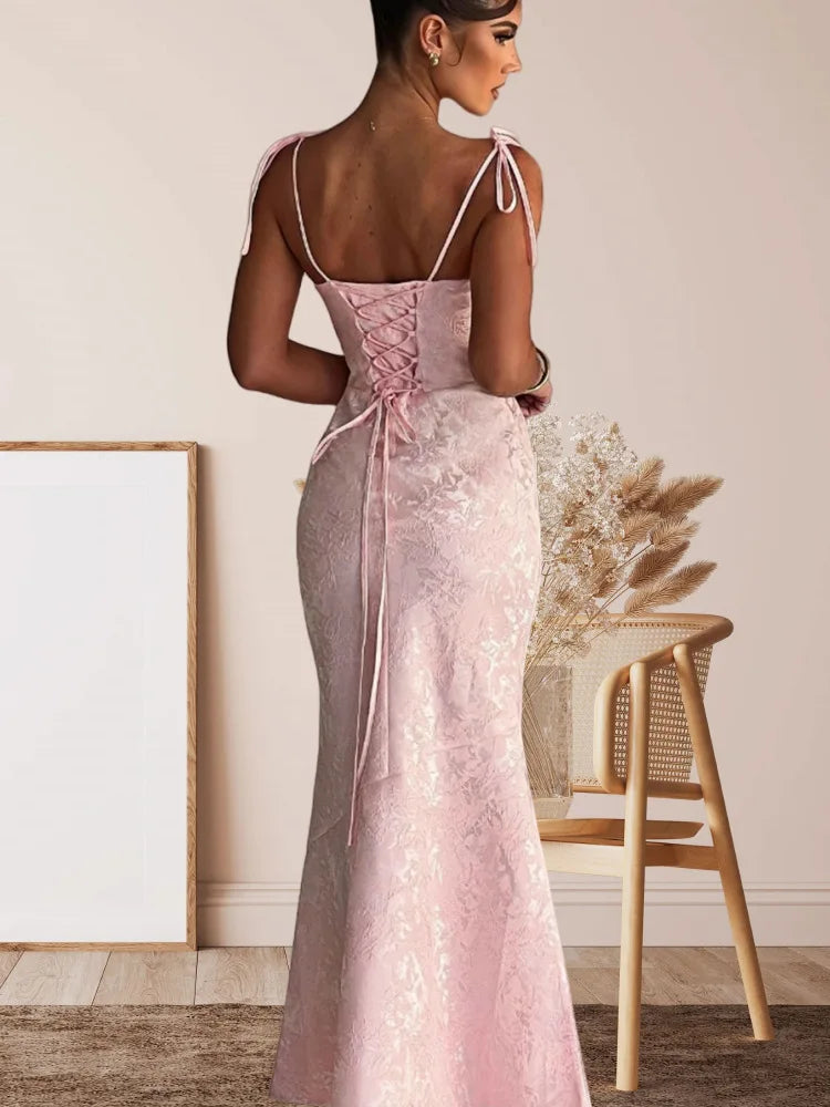 Woman wearing a pink lace-up dress with a neutral background