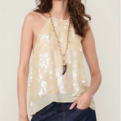 Woman wearing a beige sequin top with a necklace on a plain background