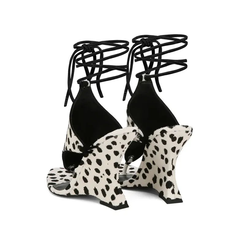 Black strappy top with white polka dot shoes on a white background