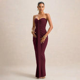 Woman wearing a burgundy strapless gown on a beige background