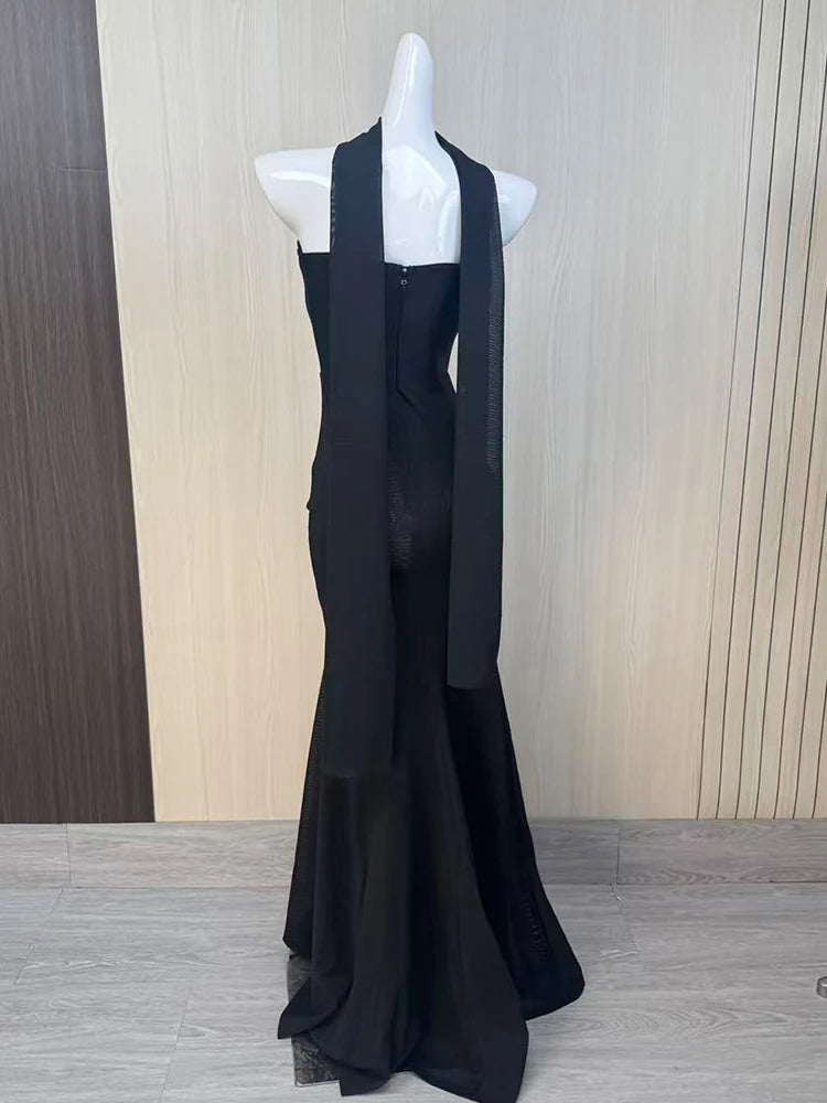 Black evening gown on a mannequin against a wooden panel background