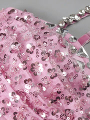 Pink glittery fabric with silver sequins on a gray background