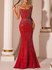 Red evening gown with sparkling details against a classical architecture background