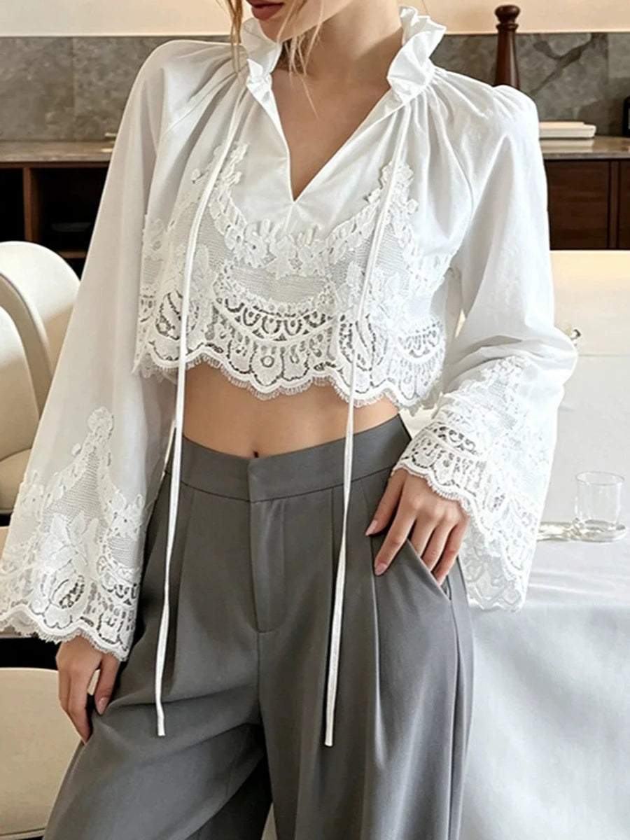 White lace-trimmed cropped blouse with long sleeves and tie-front V-neck
