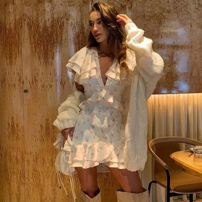 Woman in a floral ruffled V-neck mini dress styled with boots