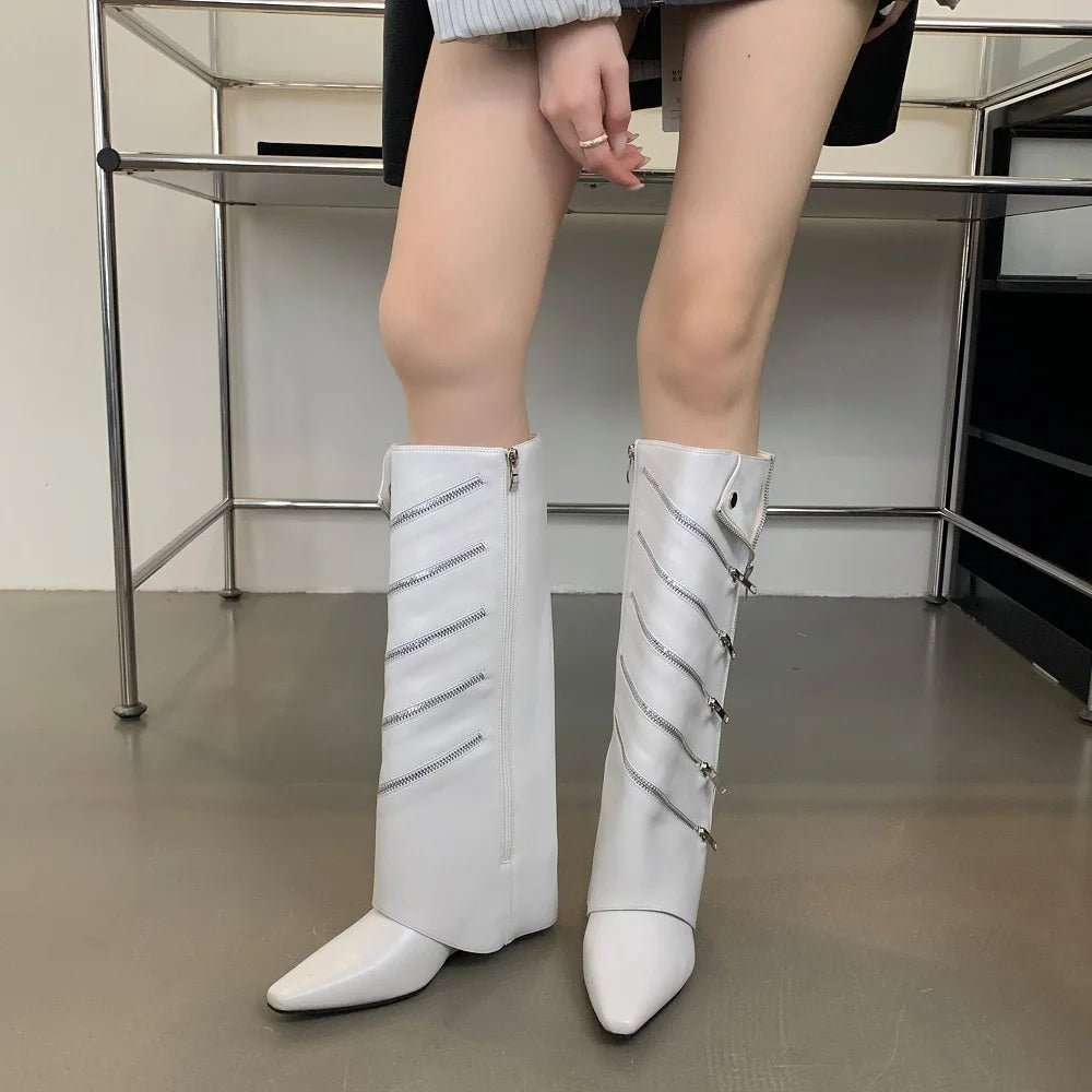 White knee-high boots with decorative elements worn by a person indoors.
