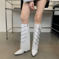 White knee-high boots with decorative elements worn by a person indoors.