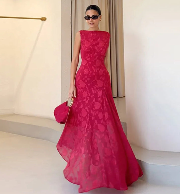 Woman in a pink lace dress standing indoors with a neutral background