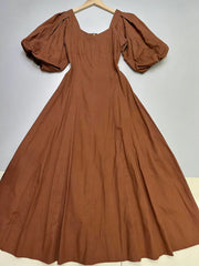 Brown dress with puff sleeves on a hanger against a white background