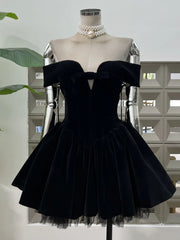 Black off-shoulder dress on a mannequin with a pearl necklace against a light background