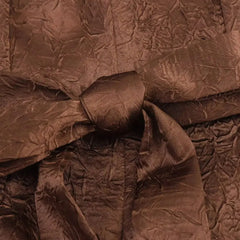 Close-up of crumpled brown fabric with a bow