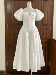 White dress on a mannequin against a wooden door background
