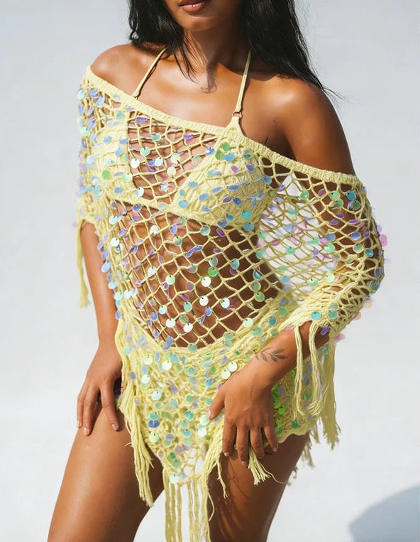 Yellow sequin knit poncho with fringe hem worn by a model.