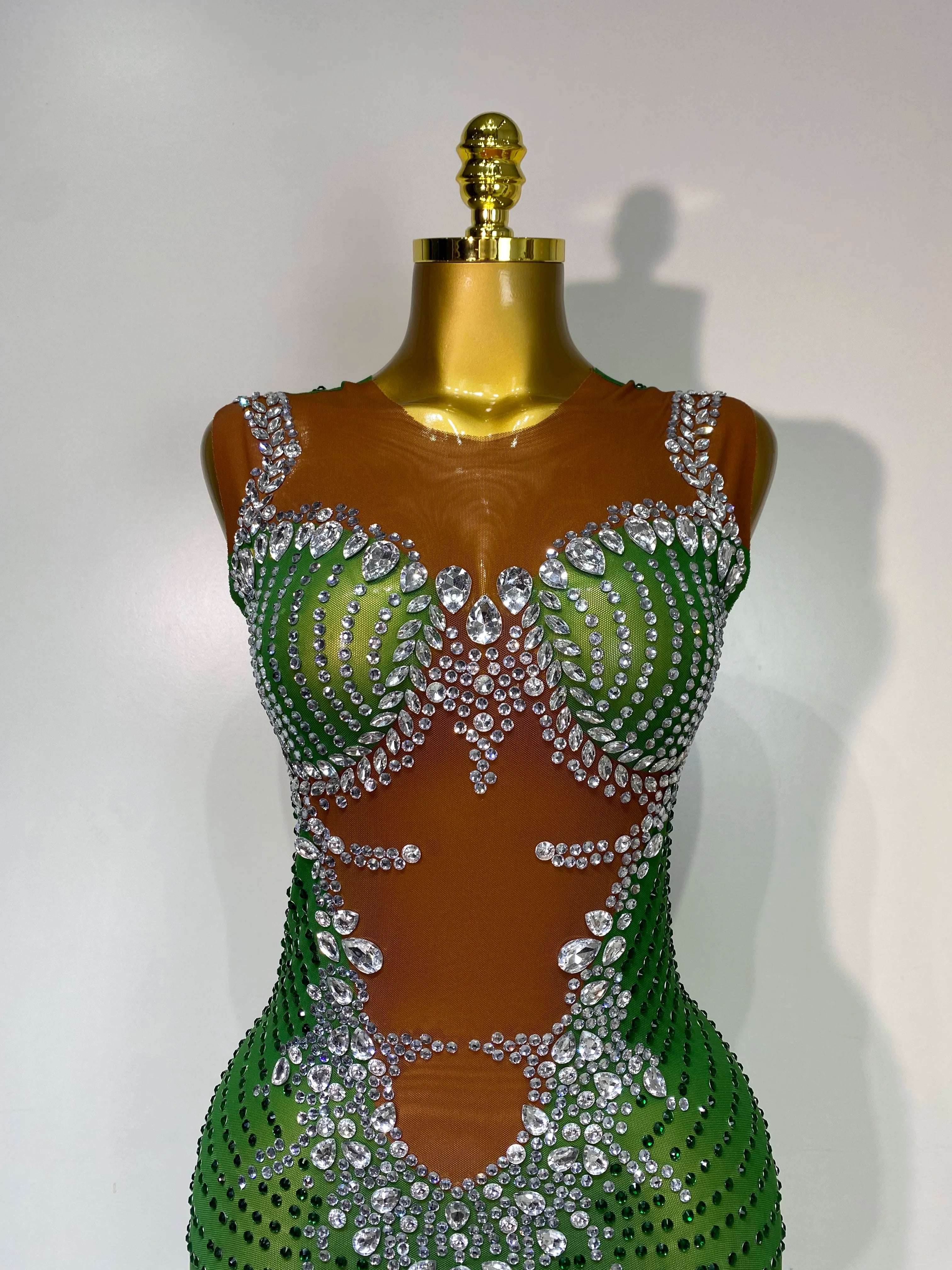 Green and silver beaded dress on a mannequin against a white background