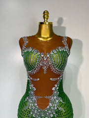 Green and silver beaded dress on a mannequin against a white background