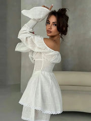 Woman wearing a white dress with ruffled sleeves against a neutral background