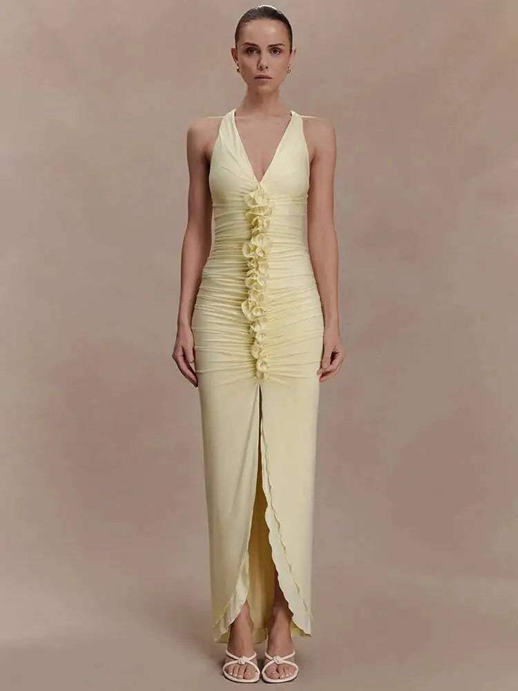 Woman wearing a light yellow evening gown with a deep neckline and ruched details on a beige background