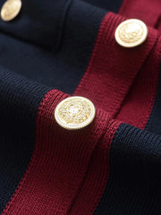 Close-up of a navy and red striped garment with gold buttons.